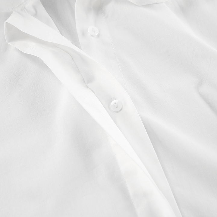 Close-up van de kraag en strik van het elegante witte dames overhemd, een klassieke strikblouse.