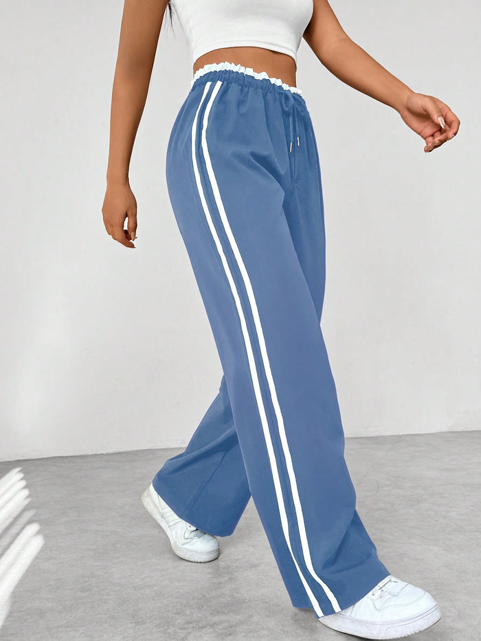 Donkerblauwe joggingbroek met witte strepen, elastische tailleband, sportief en trendy design, damesmode.