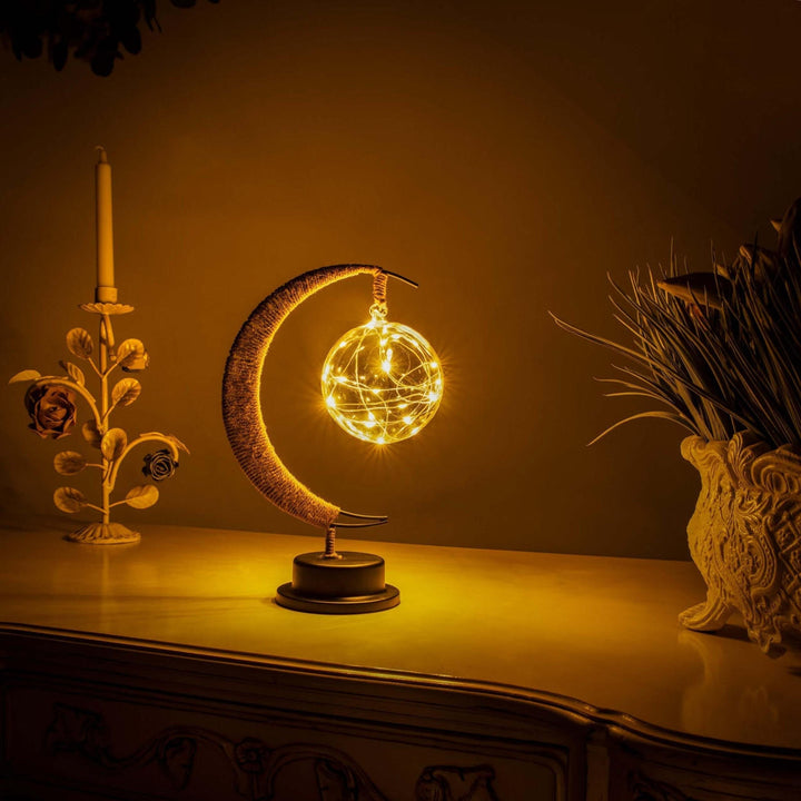 "Dromerige maanlamp van borosilicaatglas met zachte LED-gloed, creëert een betoverende sfeer op tafel."