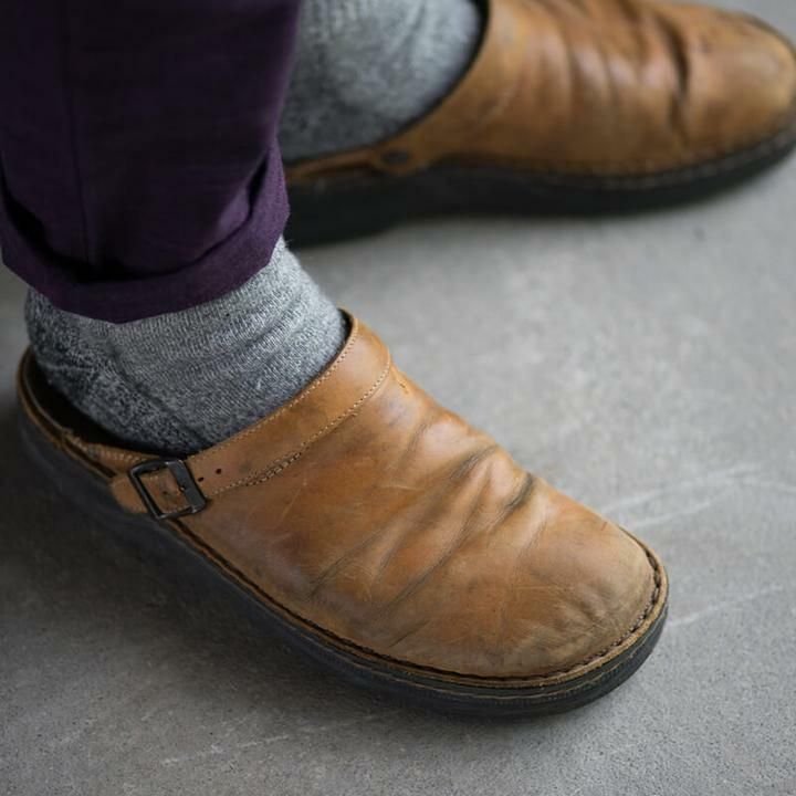 Man draagt casual orthopedische heren pantoffels, genietend van comfort en ondersteuning thuis of buiten.