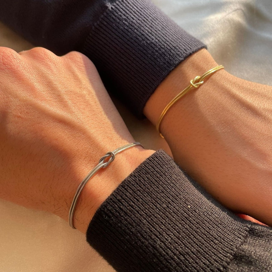 "Elegant gouden liefdesknoop armband voor dames, minimalistisch ontwerp, tijdloos en verfijnd accessoire."