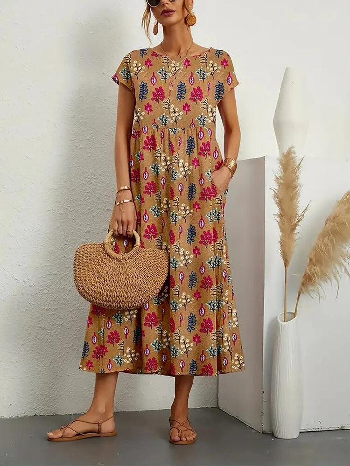 "Elegante A-lijn zomerjurk met kleurrijke bloemenprint, korte mouwen en lange rok, gemaakt van licht katoenen stof."