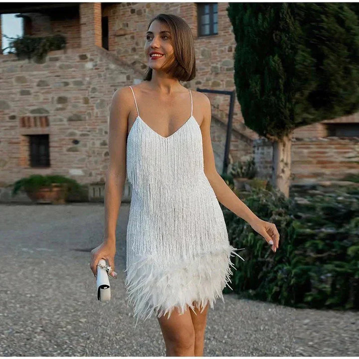 "Elegante cocktailjurk met franjes en veertjes, perfect voor feestjes, met aansluitende pasvorm en uitlopende rok."