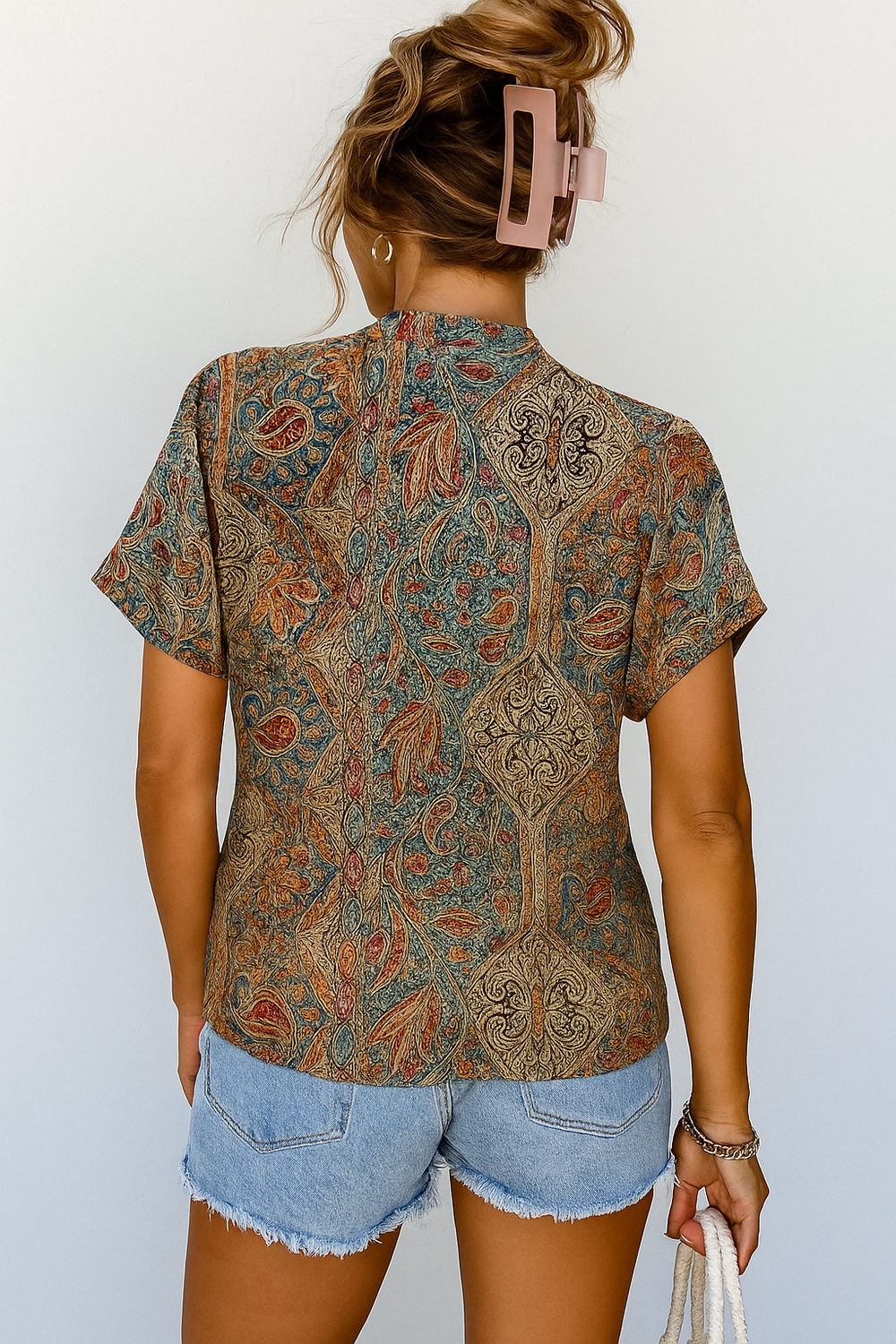 Modieuze meerkleurige damesblouse met luchtige V-hals en korte plofmouwen, voorzien van trendy paisley print.