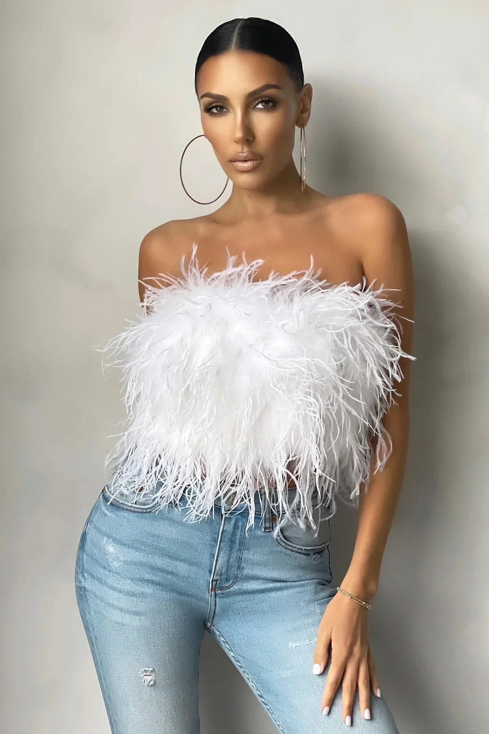 Trendy mouwloze crop top voor dames, chique avondkleding met veren accent.