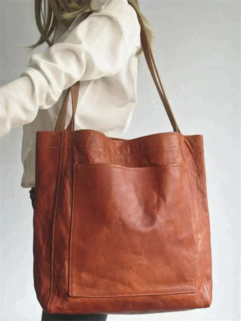 Donkerbruine vegan leren dames handtas, ruim en elegant met verstelbare riem. Stijlvol en duurzaam accessoire.