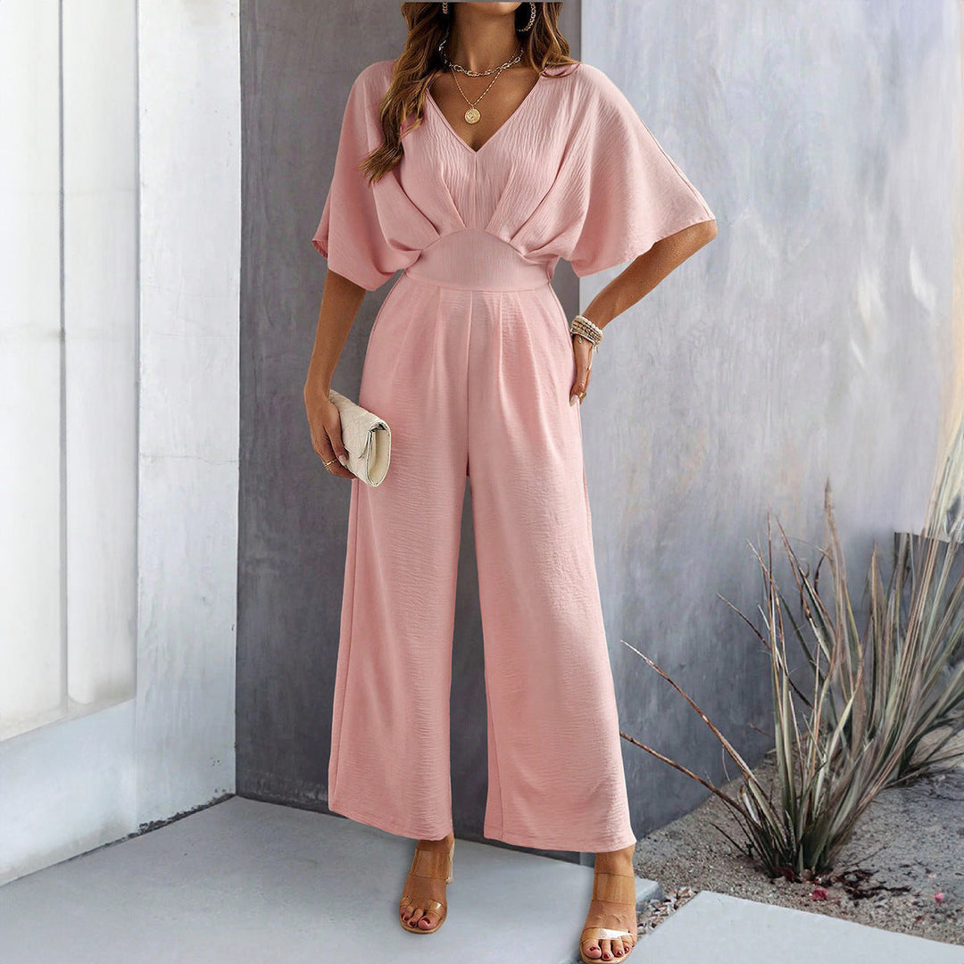 Model toont elegante dames jumpsuit met V-hals en vloeiende wijde pijpen; chique dameskleding.