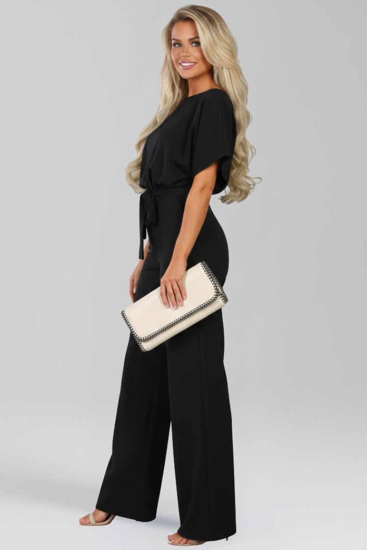 Dames jumpsuit met strikceintuur, wijde pijpen en boothals, geschikt als casual of feest outfit. Trendy en elegant.