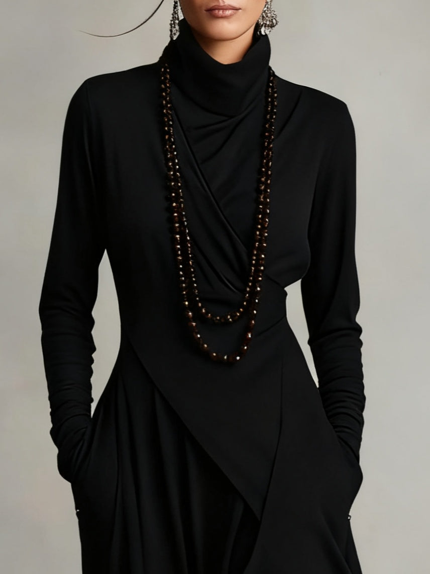 Zwarte dames maxi jurk met hoge col, lange mouwen en een flatterende asymmetrische rok. Tijdloze stijl.