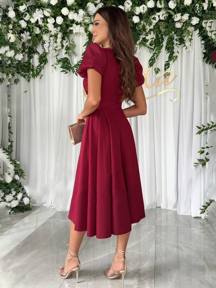 Dames cocktailjurk: elegante midi jurk met pofmouwen, V-hals en uitlopende rok. Stijlvolle feestjurk.