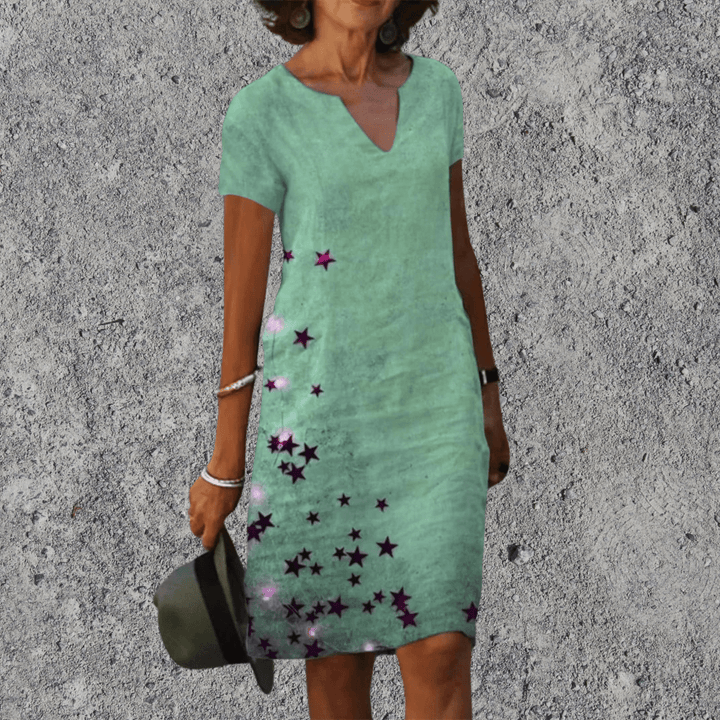 Model draagt modieuze dames midi jurk met V-hals en korte mouwen, ideaal voor een zomerse look.