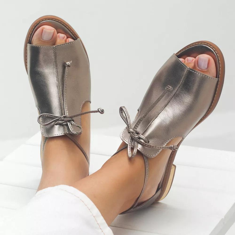 Gouden platte dames sandalen met strikbandje en open neus. Comfortabele zomersandalen met platte zool voor dames.