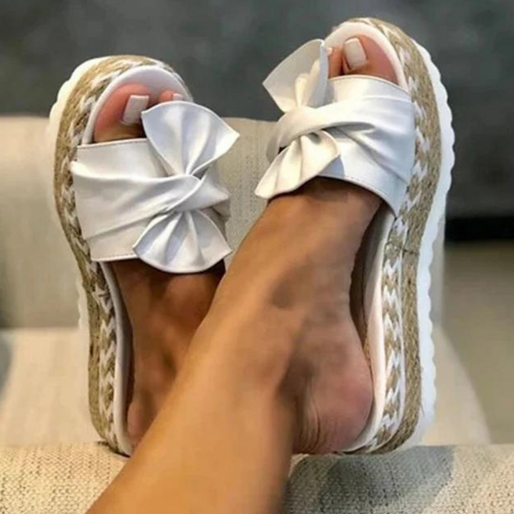 Stijlvolle zomer sandalen voor dames met een elegant strikdetail. Platte, comfortabele schoenen voor een moderne look.