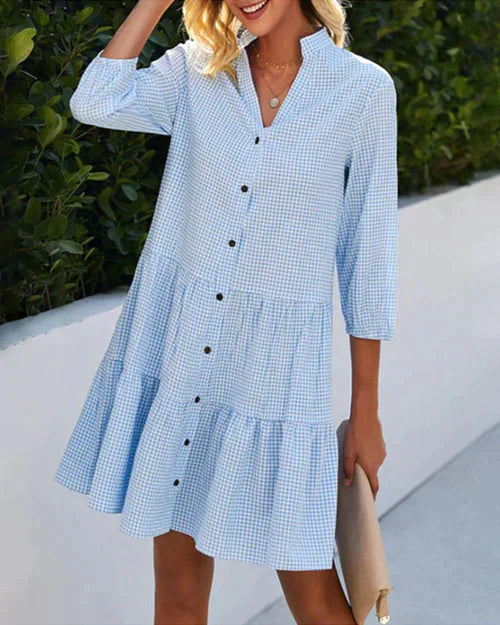 Elegante dames zomerjurk met diepe V-hals en modieus ruitpatroon. Perfect voor lente en zomer.