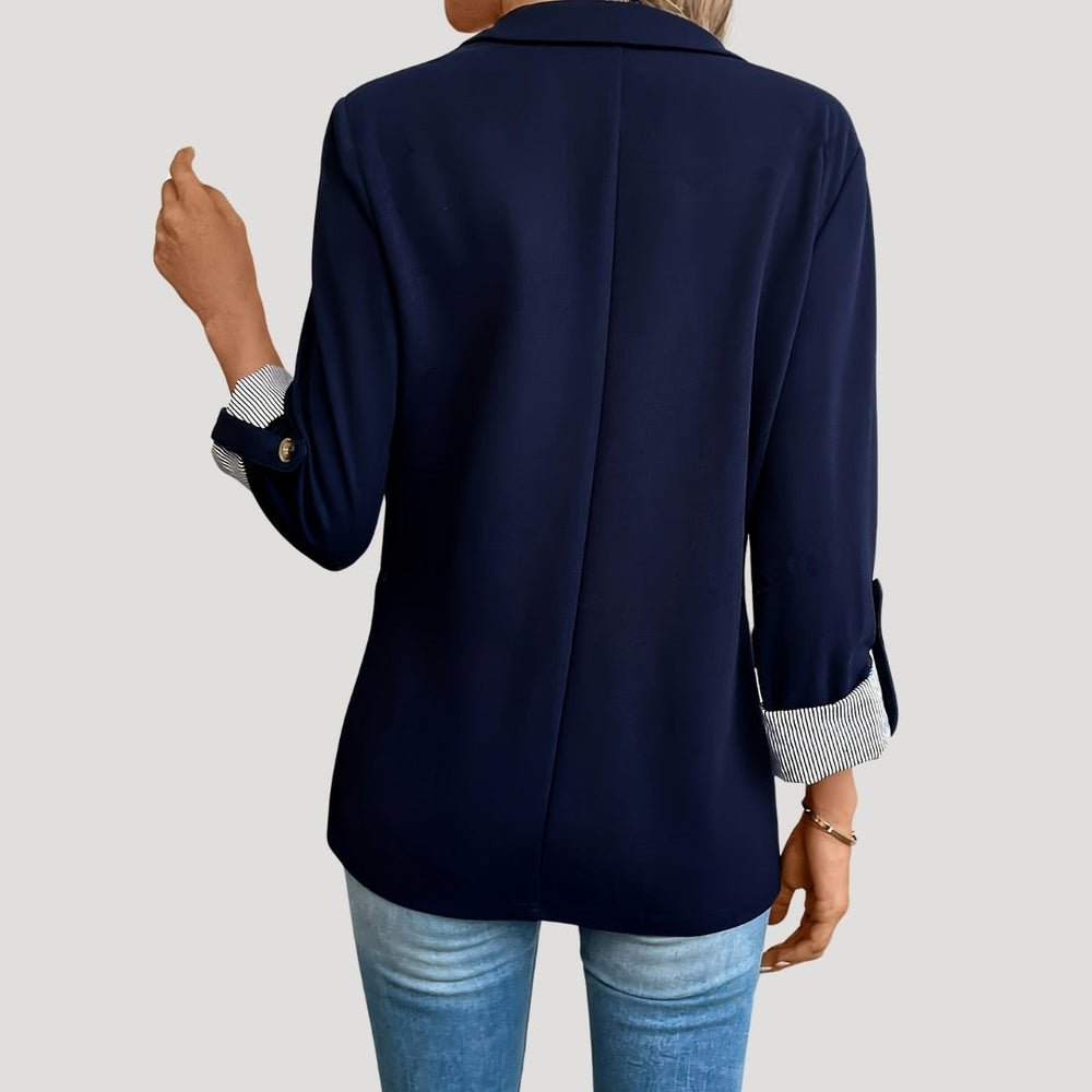 Dames blazer detail: stijlvolle opgerolde mouwen tonen de getailleerde snit, perfect voor een moderne look.