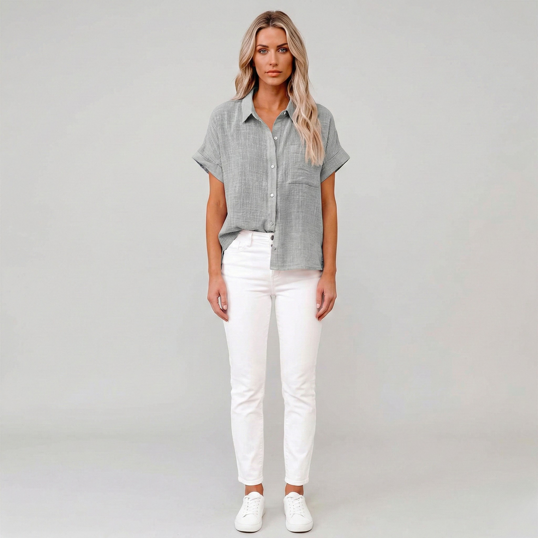 Luchtige damesblouse met korte mouwen, klassieke kraag en ruime pasvorm, ideaal voor warme zomerdagen.
