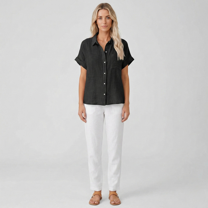 Vooraanzicht van een modieuze damesblouse met korte mouw, klassieke kraag en nette knoopsluiting.
