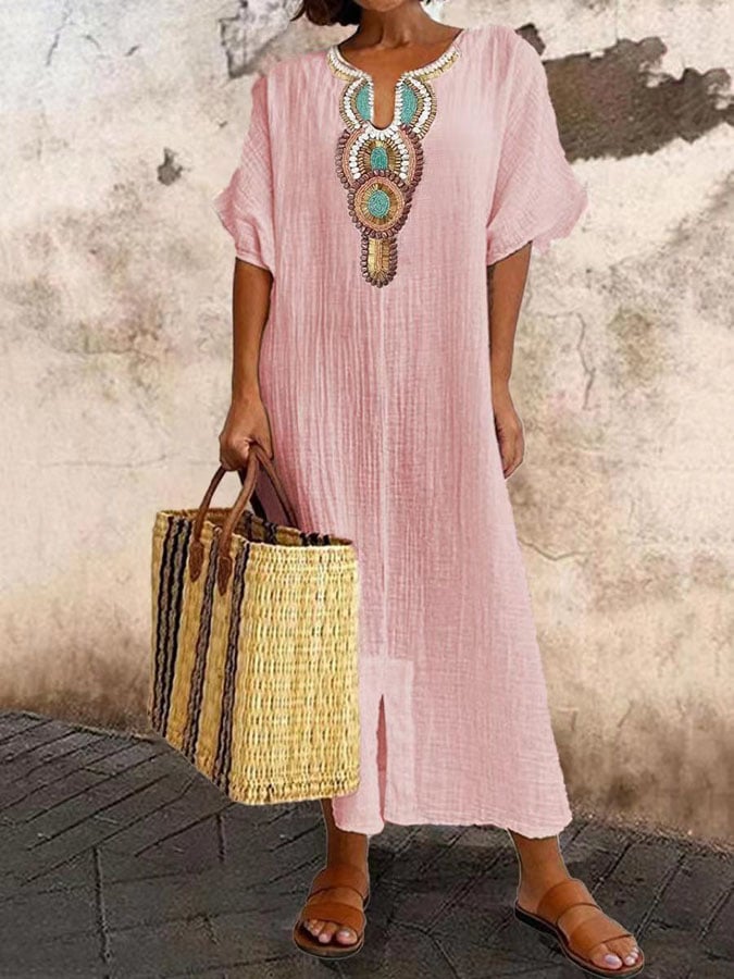 Detailopname van het ingewikkelde geborduurde patroon op de bohemian maxi kaftan damesjurk.