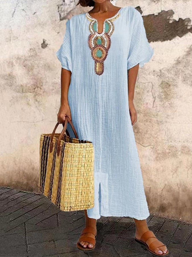 Model toont de sierlijke pasvorm van de geborduurde zomerse maxi kaftan jurk voor dames.