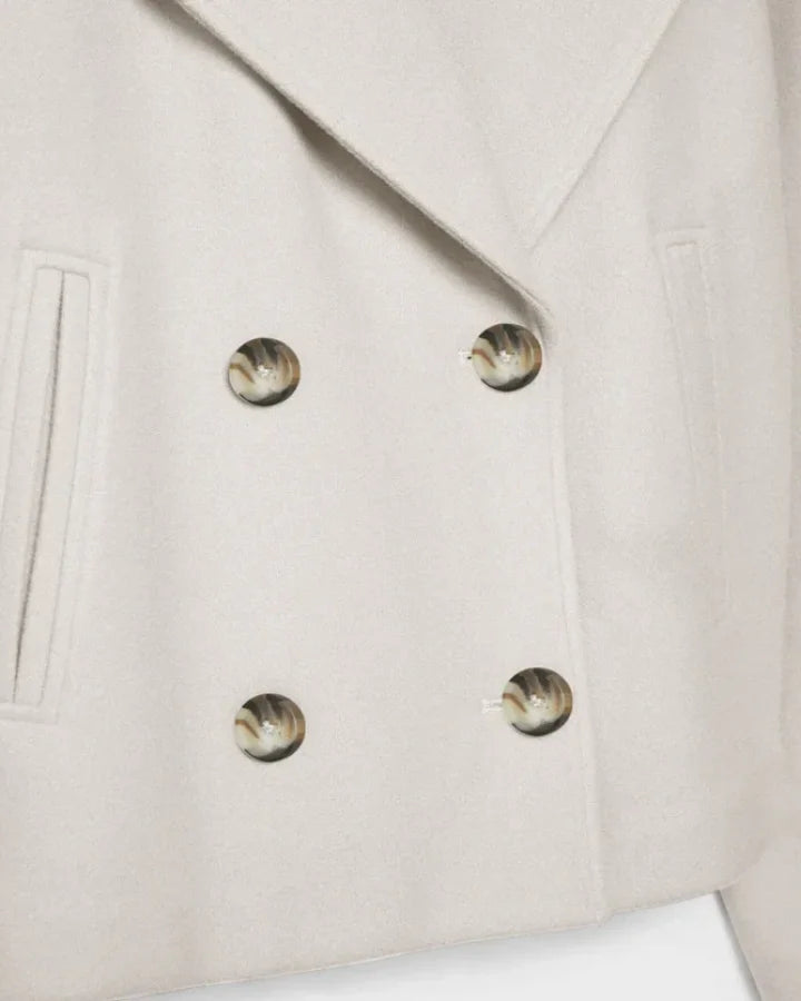 Stijlvolle gebroken witte damesjas, kort en double breasted, perfecte bovenkleding voor herfst en wintermode.