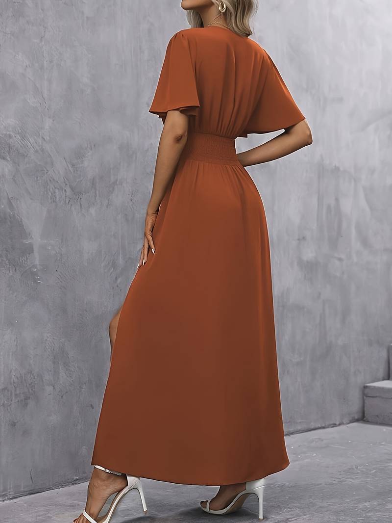 Detail van de stijlvolle split in karamel lange damesjurk, ideaal voor een casual of feestelijke look.
