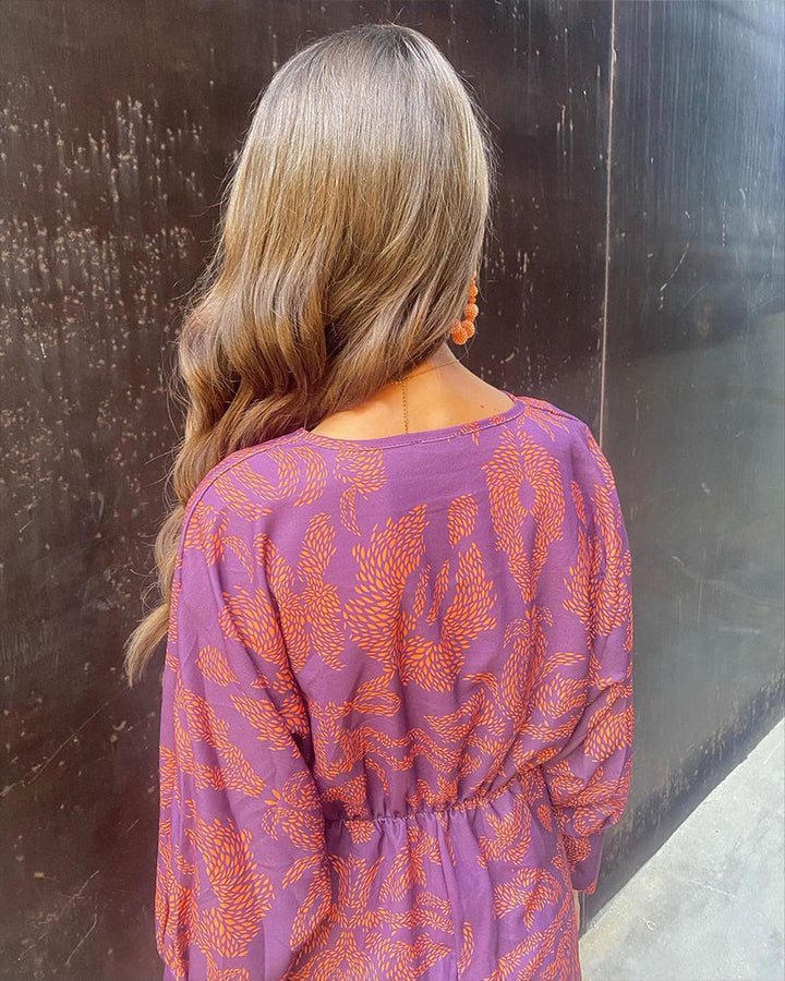 Model draagt de Oriana jurk met lange mouwen, blauw, voor een formele gelegenheid.