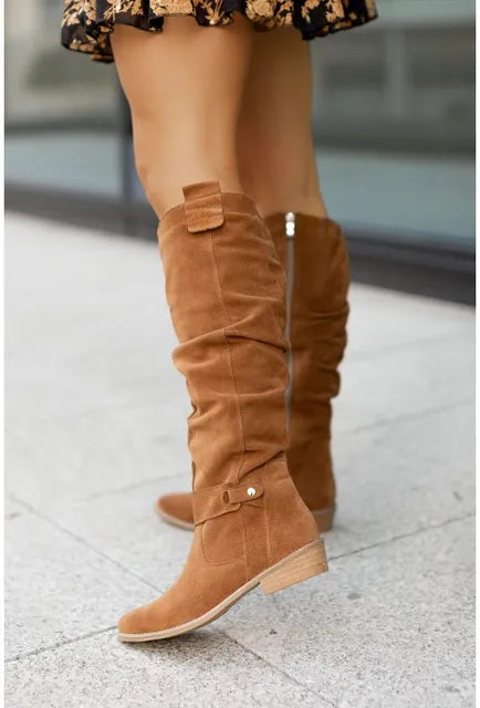 Vrouw draagt stijlvolle Liv dames laarzen met hak, passend bij diverse outfits. Perfect voor wintermode.