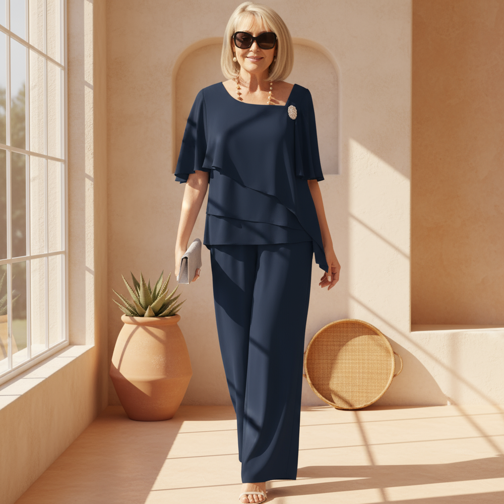 Close-up van asymmetrische marineblauwe overlay top met vlindermouwen, deel van een stijlvolle dames co-ord set.