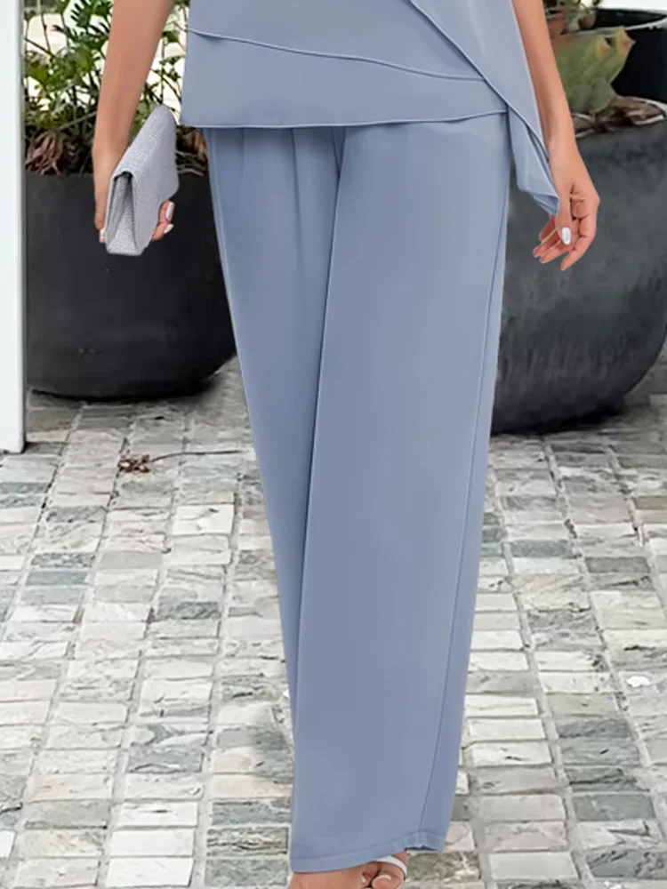 Volledige outfit van een blauwe dames tweedelig set met wijde broek en asymmetrische top, perfect voor feest of zomer.