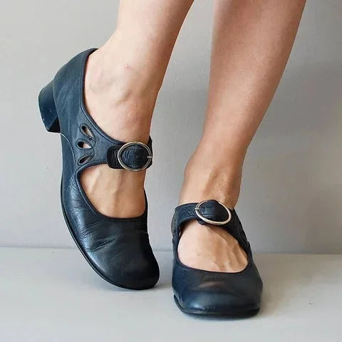 Zwarte damespumps met glimmende siergesp, perfect voor een chique of zakelijke look.