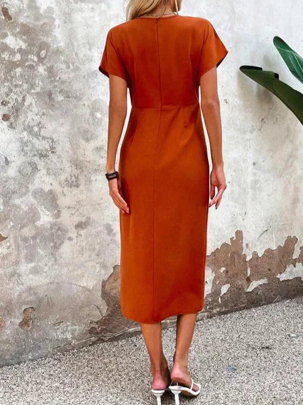 Stijlvolle oranje dames midi jurk met V-hals en korte mouwen. Elegante flatterende jurk voor diverse gelegenheden.