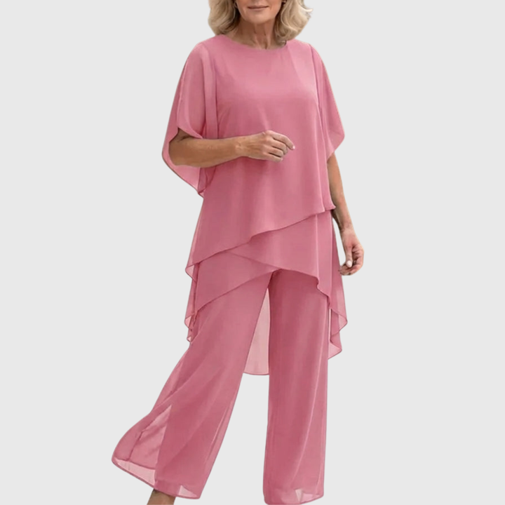Model toont vloeiende tweedelige dames set. Comfortabel en stijlvol met een elegant silhouet.