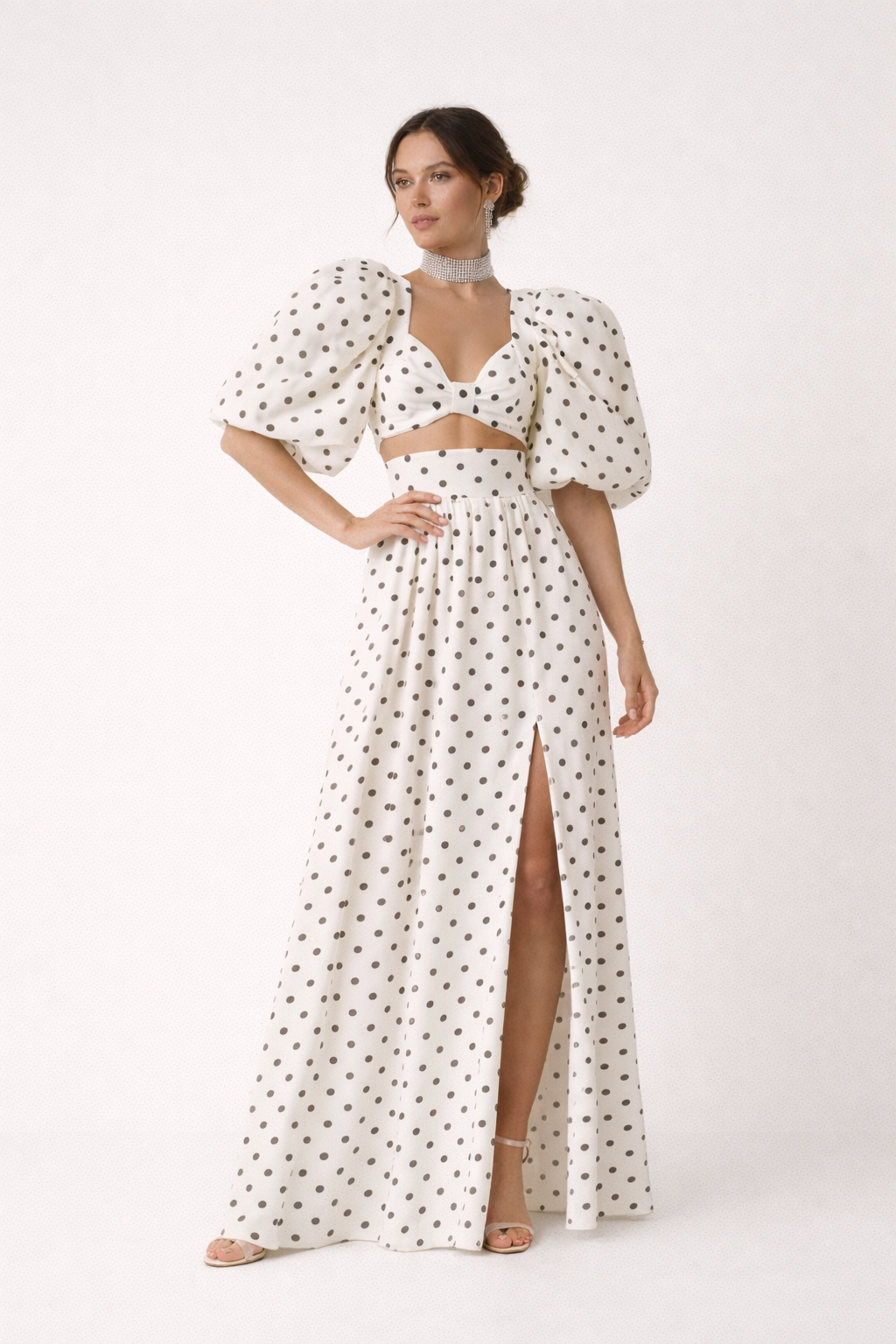 Dames topset met bolletjesprint, pofmouwen top en lange, elegante maxirok. Ideaal voor zomeravonden.