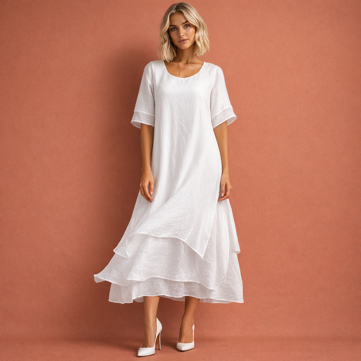 Elegante witte dames midi jurk met ronde hals en zwierige volantzoom, perfect voor zomerse dagen. Comfortabel en stijlvol.