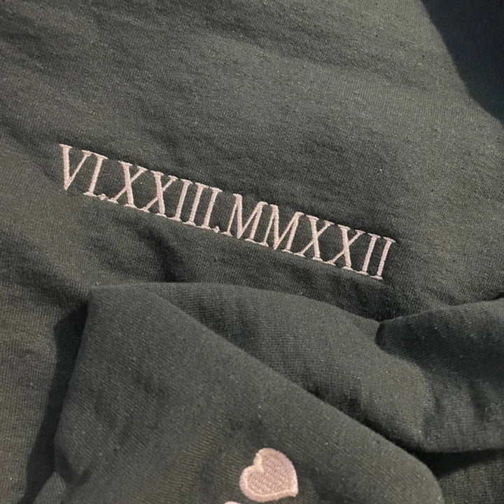 Close-up van custom Romeinse cijfers op een gepersonaliseerde koppel hoodie, uniek ontwerp.