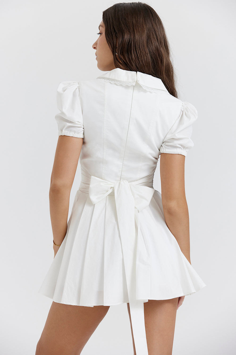 Elegante geplooide dames mini-jurk met V-hals en pofmouwen, perfect als feest- of casual lentejurk.