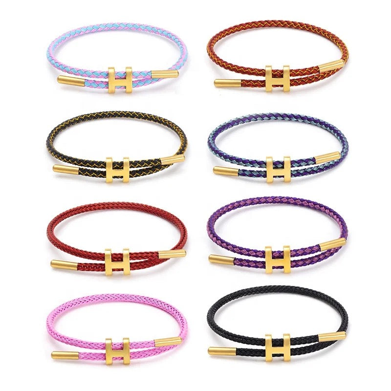 Stijlvolle gevlochten touw armband, unisex, met glanzende H-sluiting. Elegant accessoire dat elke look afmaakt.