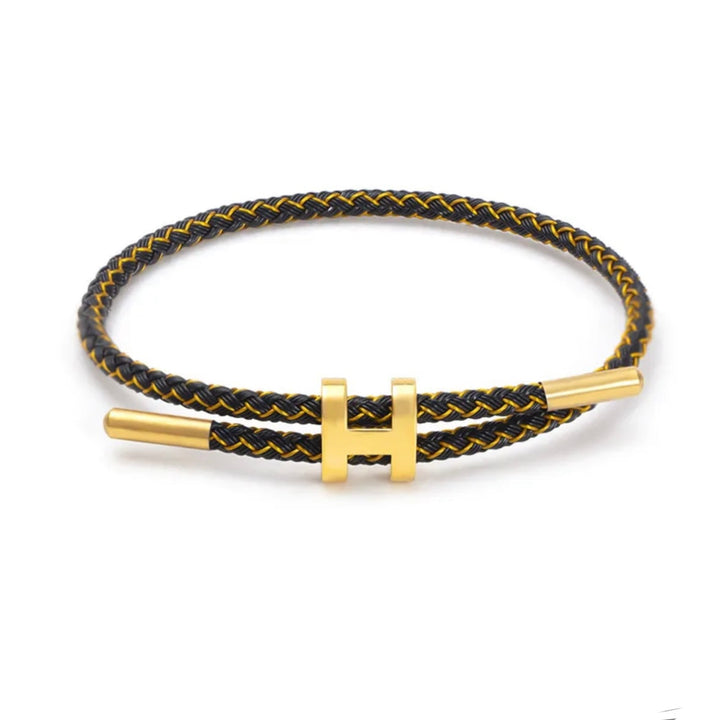 Unisex gevlochten armband met H-sluiting om een pols, toont elegantie en modern design. Een stijlvol sieraad.
