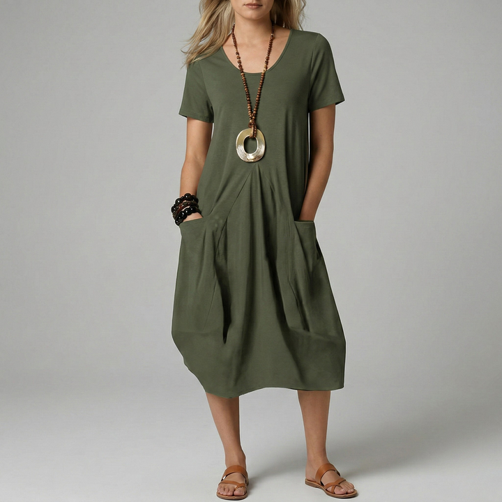 Beige losvallende dames midi jurk met V-hals en korte mouwen. Comfortabele zomerjurk met handige zijzakken.