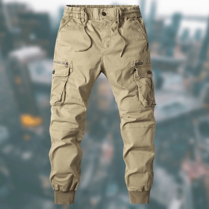 Man draagt een moderne heren jogger broek met cargozakken, ideaal voor een casual lente outfit.
