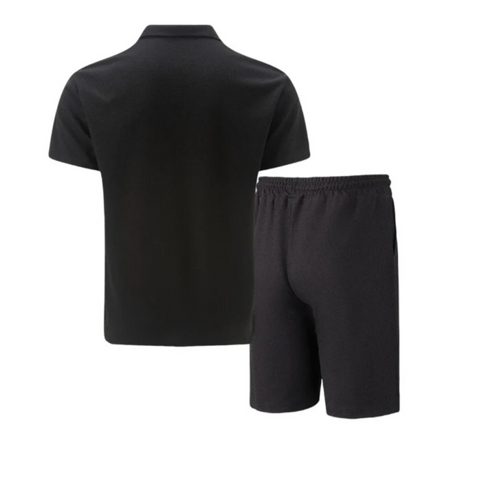 Model draagt stijlvolle heren co-ord set: polo & korte broek voor een complete zomerse vrijetijdslook.