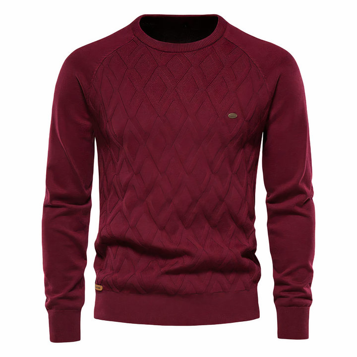 Model draagt een trendy heren gebreide trui met diamantpatroon, slanke pasvorm. Ideaal voor stijlvolle winterse looks.