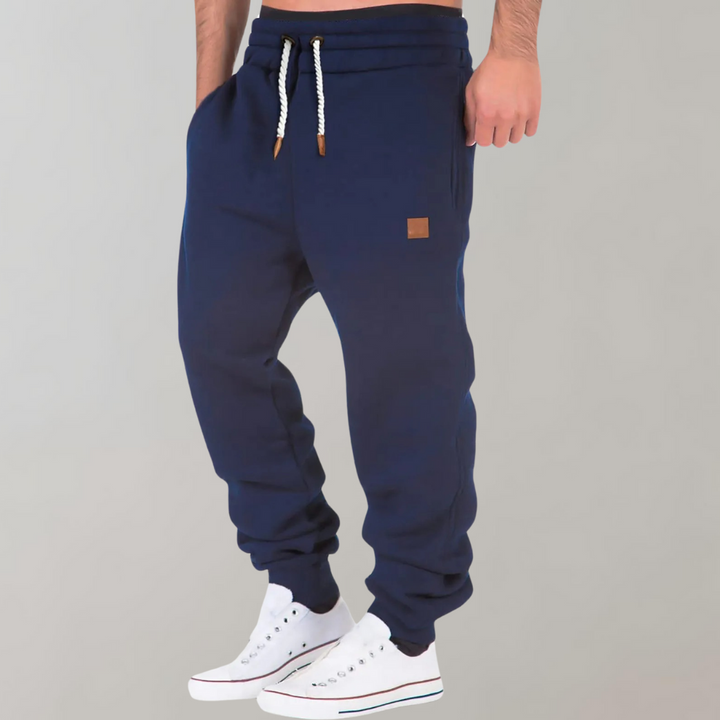Heren joggingbroek met trekkoord, rechte pijpen en zijzakken. Comfortabel voor sport of vrije tijd.