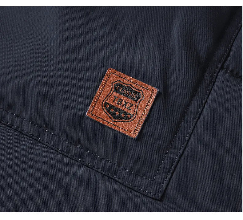 Man draagt een casual waterafstotende heren parka winterjas met warme voering en capuchon, staand.