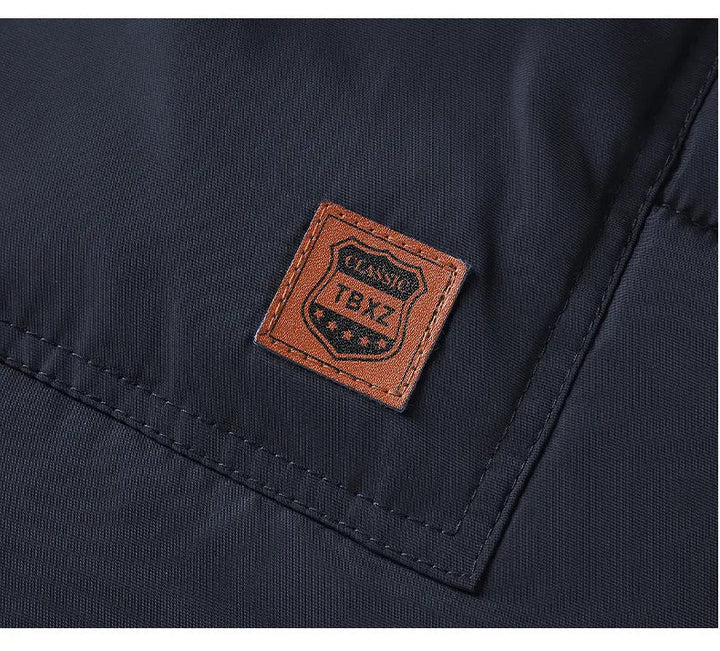 Man draagt een casual waterafstotende heren parka winterjas met warme voering en capuchon, staand.