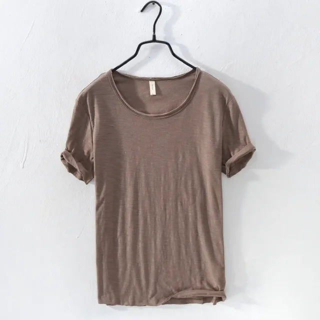 Model draagt slim-fit heren retro T-shirt met ruwe rand. Trendy en casual voor zomerse gelegenheden.