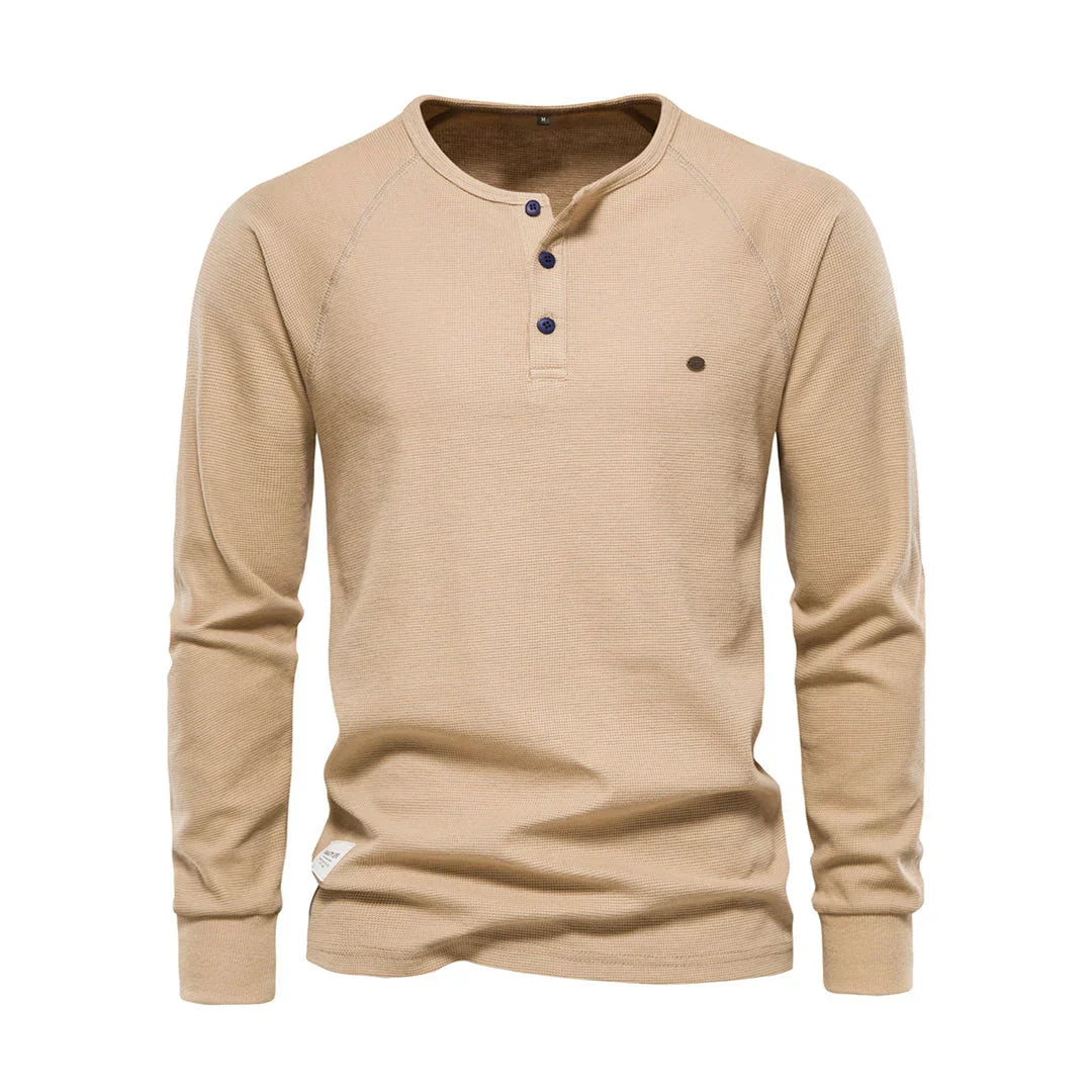 Man toont casual herenshirt met lange mouwen en ronde hals in een ontspannen pose, comfortabel en modieus.