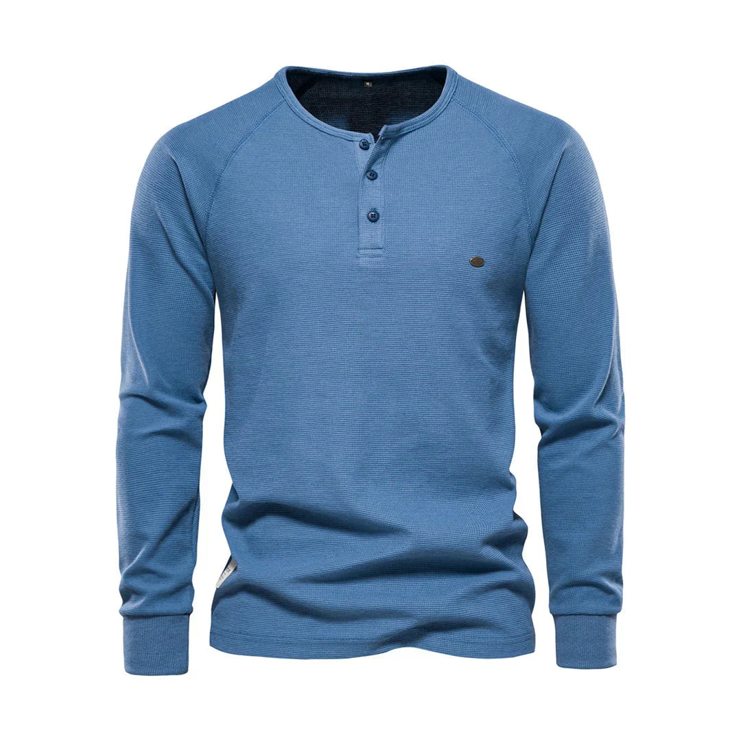 Kledingstapel van herenshirts met lange mouwen en ronde hals in diverse kleuren, voor de veelzijdige garderobe.