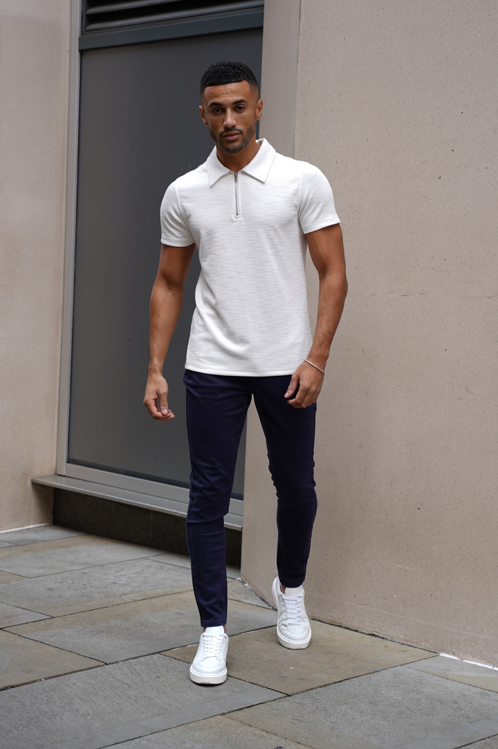 Detailopname van de elastische tailleband en getaperde enkels van deze slim fit heren chino broek, pure herenmode. (nl)