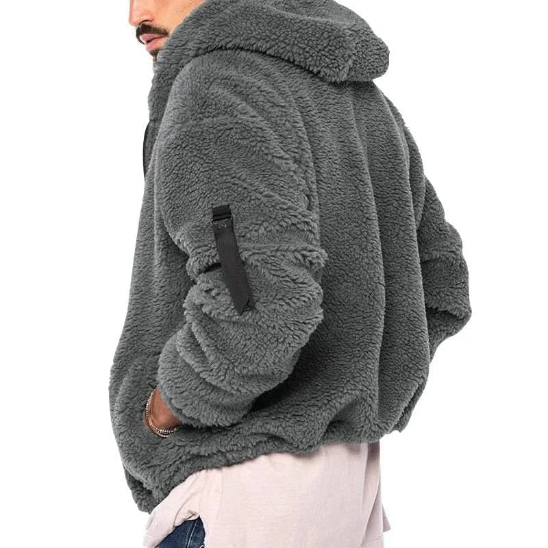 Man draagt comfortabel grijs teddy fleece herenvest met capuchon. Ideaal voor casual winterkleding.